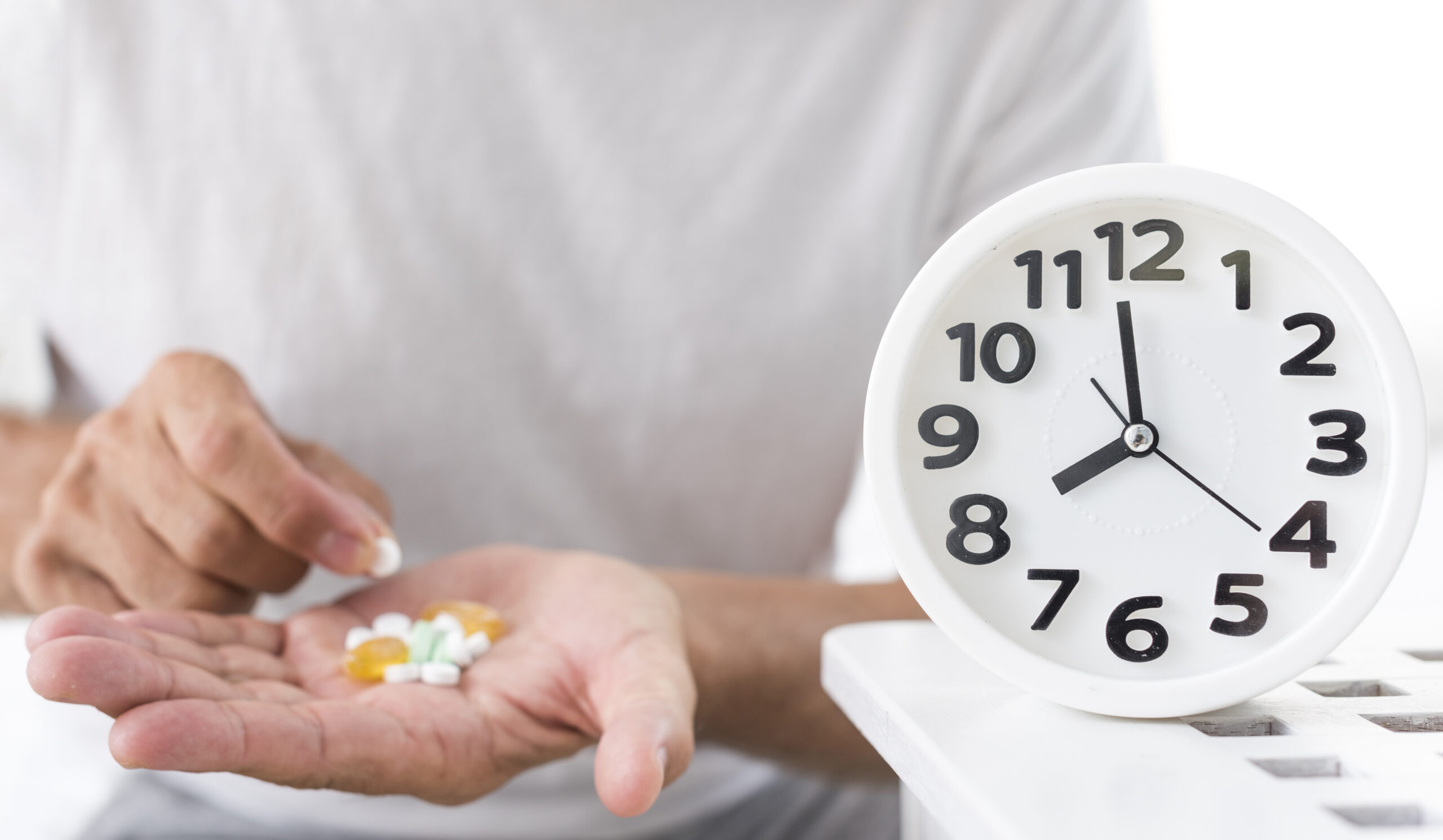 Man taking medication with clock telling time
