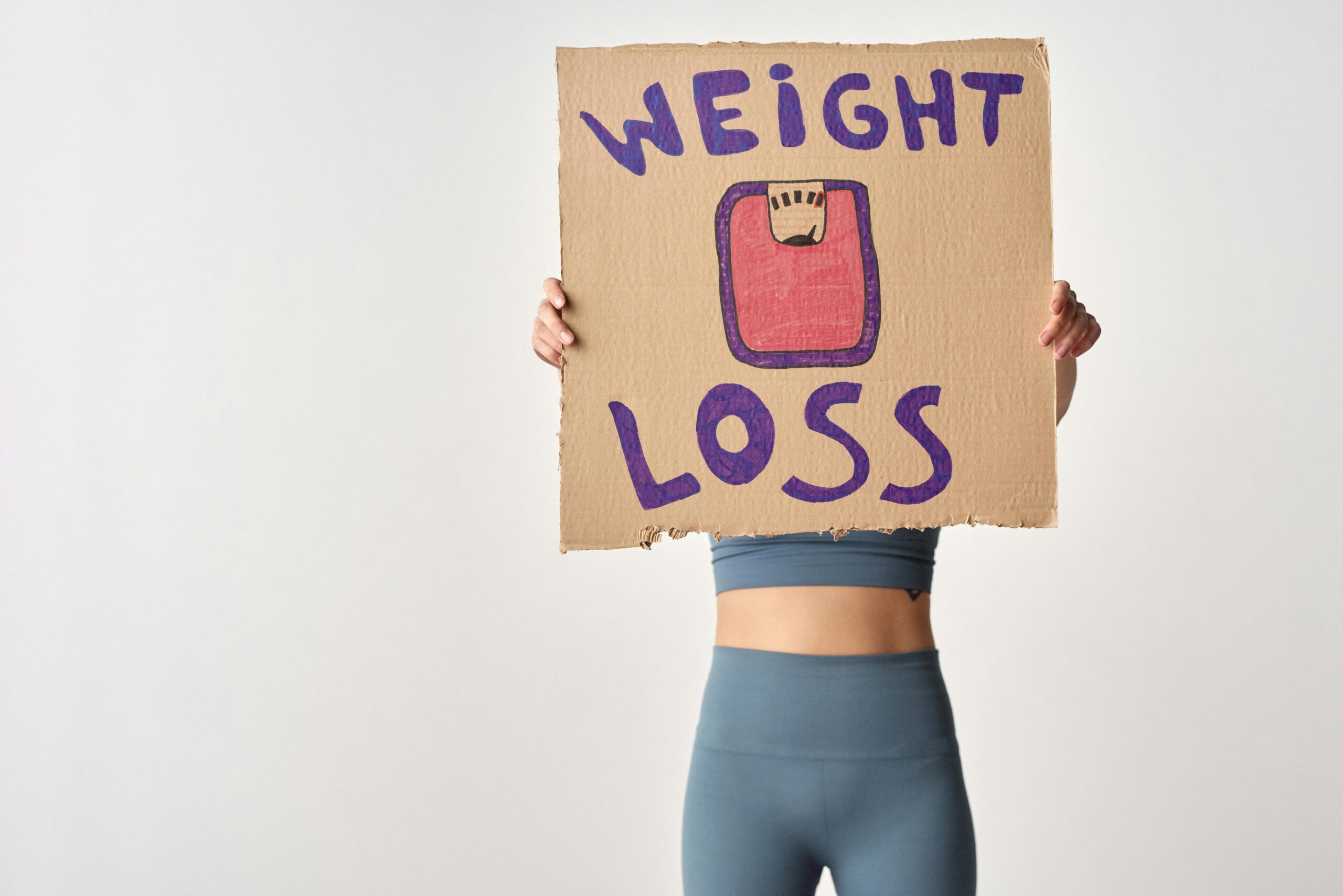 woman holding a weight loss placard