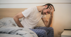 Man in bed waking up with morning sickness