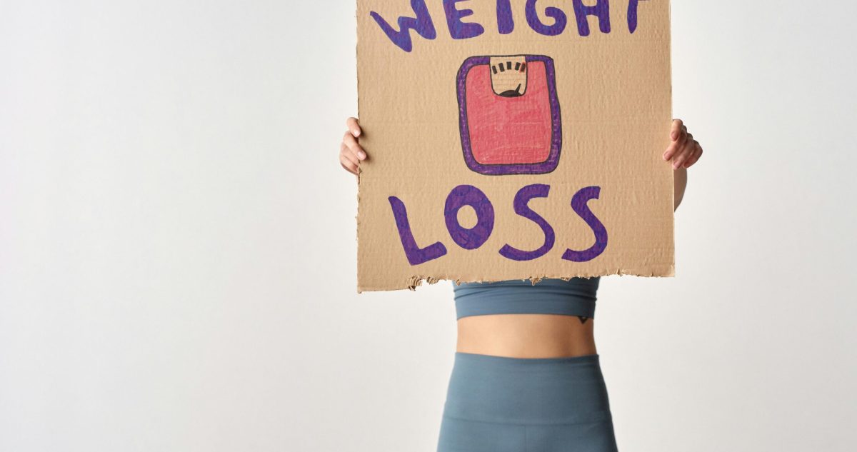 woman holding a weight loss placard